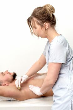 Young man receiving waxing underarm