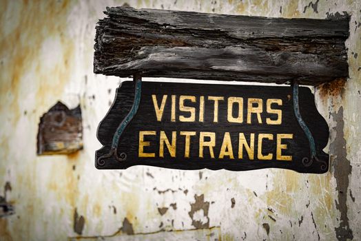 Old visitors entrance sign on wall