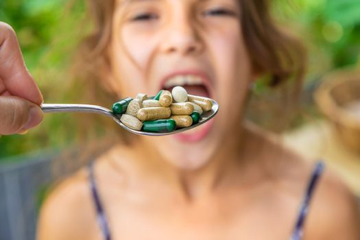 A spoonful of supplements and vitamins for a child. Selective focus.