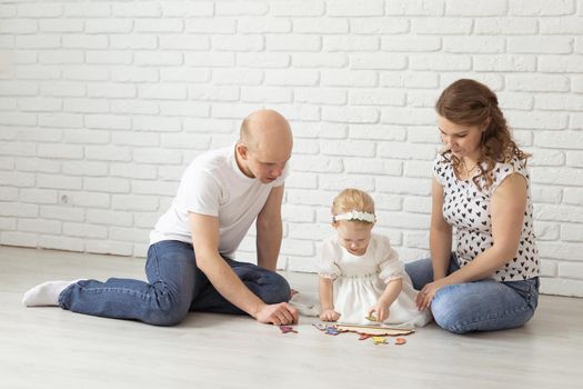 Baby child with hearing aids and cochlear implants plays with parents on floor. Deaf and rehabilitation and diversity concept