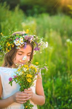 Child girl with wildflowers in summer. Selective focus.