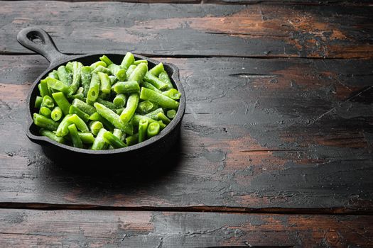 Frozen organic green beans. Healthy food concept, in frying cast iron pan, on old dark wooden table background, with copy space for text