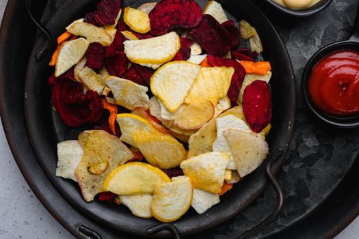 Root Vegetable Crisps, on gray stone table background, top view flat lay