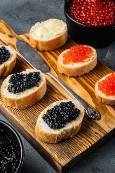 Canapes with black sturgeon and salmon fish caviar, on gray background