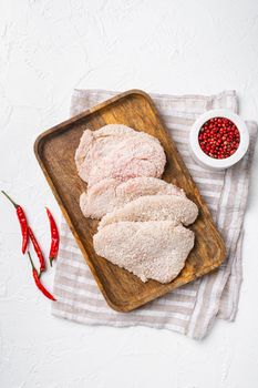 Raw schnitzel chicken meat set, on white stone table background, top view flat lay
