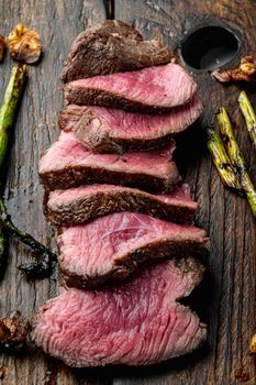 Grilled fillet mignon beef steak, with onion and asparagus, on wooden serving board