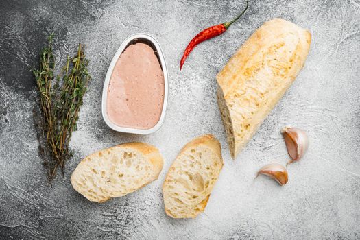 Fresh chicken liver pate from can on bread, on gray stone table background, top view flat lay