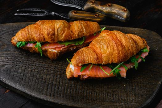 Sandwich with salted salmon, on old dark wooden table background