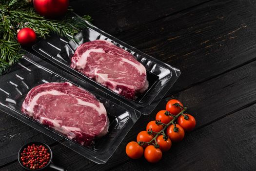 Meat in a package, on black wooden table background, with copy space for text