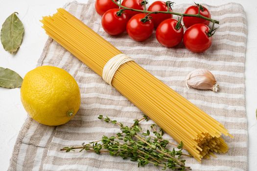 Raw ingredients for cooking italian pasta, on white stone table background