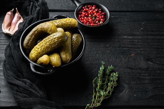 Pickled cucumbers, on black wooden table background , with space for text copyspace