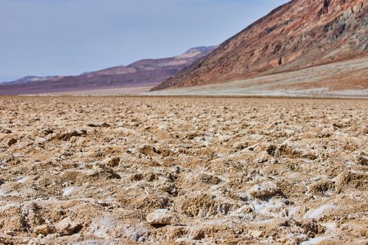 Salt flat formations in Death Valley by mountains
