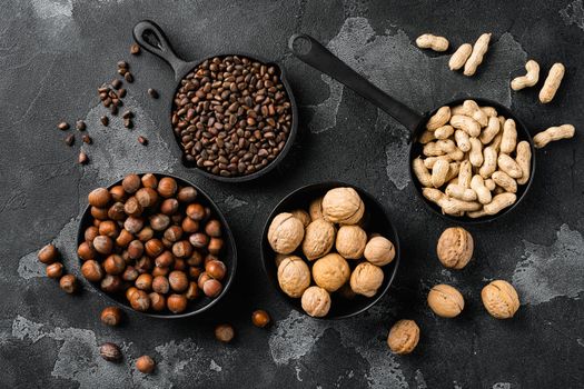Nuts mix, peanut, walnut, pine nuts and hazelnut, on black dark stone table background, top view flat lay