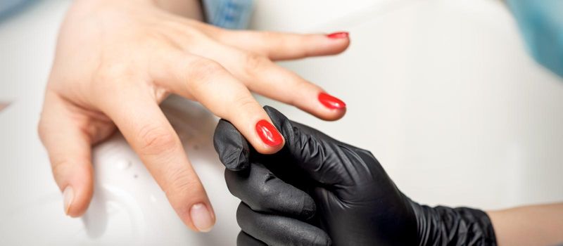 Young woman receives red nail polish