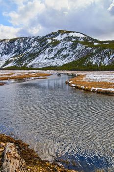Peaceful river through snowy mountains in Yellowstone