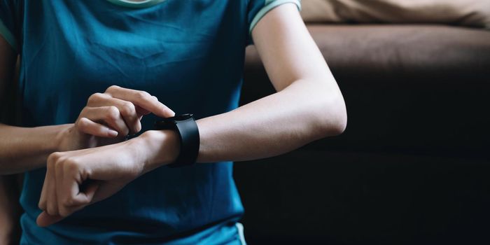 Happy woman using smartwatch for checks results in fitness app. Healthy lifestyle concept.