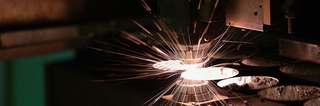 Sparks fly out machine head for metal processing laser metal