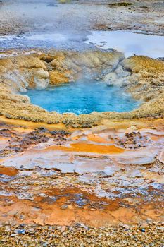 Layers of color around deep blue geyser in Yellowstone basin