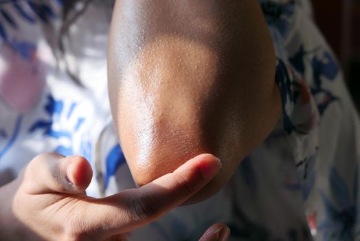 woman applying petroleum jelly onto skin at home close up.