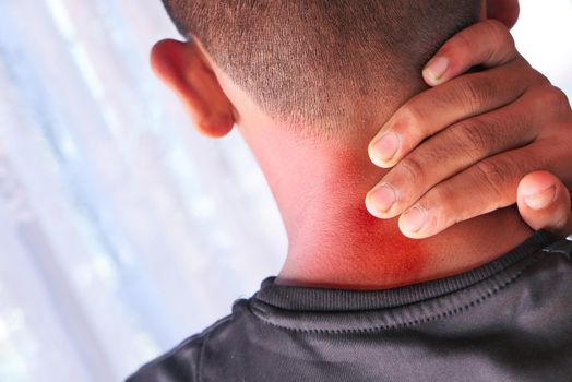 man suffering from neck or shoulder pain at home.