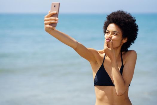 Funny black woman taking selfie at seaside