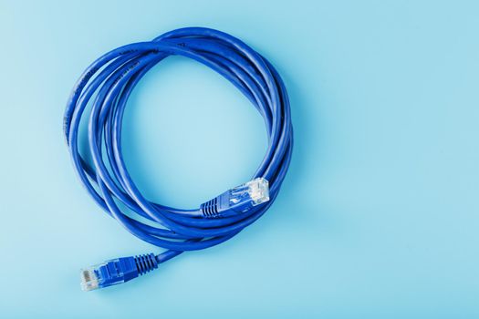 Blue Ethernet Cable Cord Patch cord on a blue background with free space