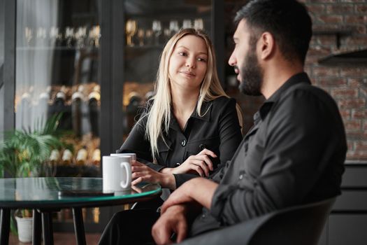 businessman and businesswoman talking sitting at a table in a cafe.