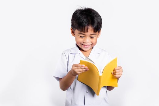Asian toddler smile happy wearing student thai uniform red pants standing holding and reading a book