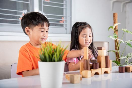 Children boy and girl playing with constructor wooden block building