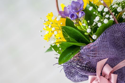 Closeup of a beautiful bouquet with purple freesia and daffodils isolated on a white background
