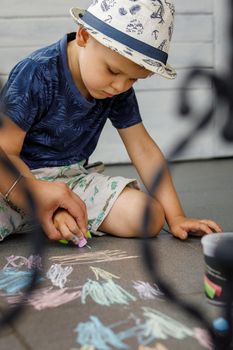 Child drawing on the road using crayon