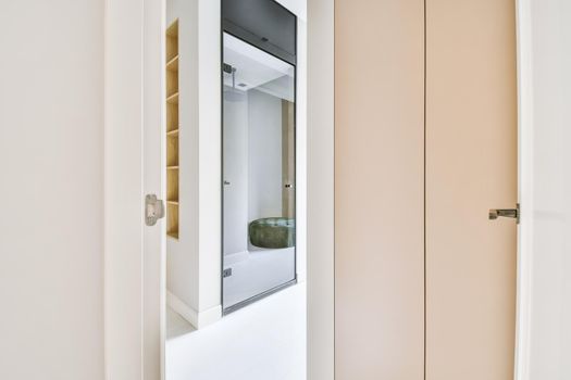 Doorway of modern apartment with white walls and parquet floor