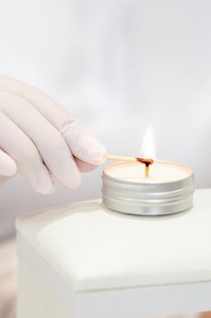 Manicure master is lighting candle