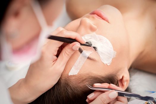 Woman receiving eyelash extensions procedure