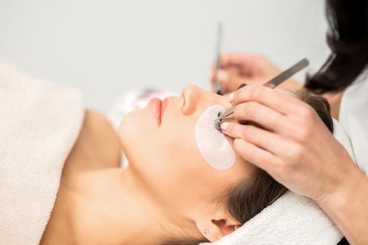 Woman having eyelash extension procedure