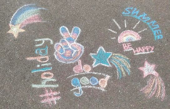 A lot of drawings on the asphalt with colorful crayon.