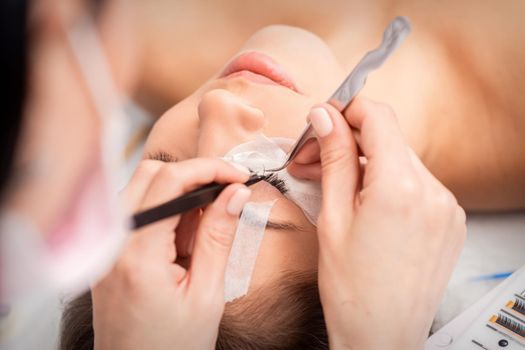 Woman receiving eyelash extensions procedure