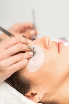 Woman having eyelash extension procedure
