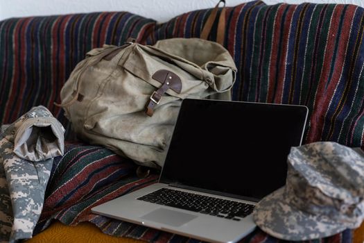 laptop. military cap, camouflage uniform