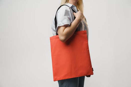 Cropped image of woman holding color shopping bag in studio