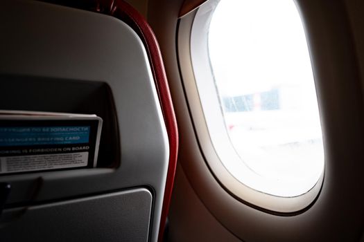 Seats and window inside a dark aircraft