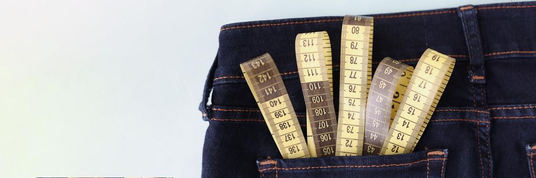 Yellow measuring tape in jeans pocket image of body slimming