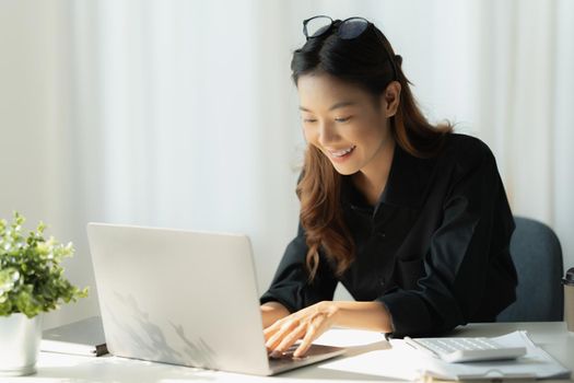 Charming Asian Business Woman working at office. Account and finance concept.