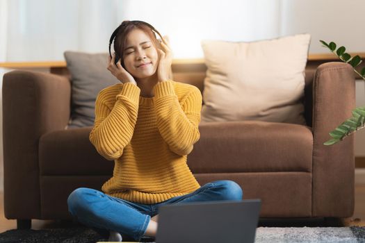 Portrait of Happy Asian artist woman using smart phone and listen music at home. Relax concept.