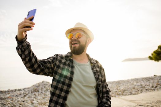 Traveler or tourist take self photo with smartphone on sea view - alone travel and technologies and millennial or gen z lifestyle