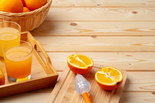 Glass of fresh orange juice with fresh fruits on wooden table