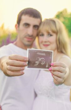 Pregnant woman and man snapshot ultrasound. Selective focus.