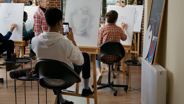 Artistic person taking photo of vase masterpiece on canvas