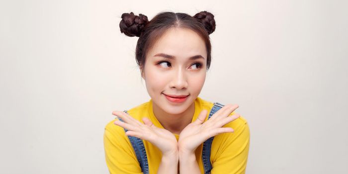 portrait of thinking young asian woman looking up doing open palm gesture in isolated studio white background