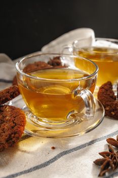 Two cups of herbal tea and cookies on kitchen cloth